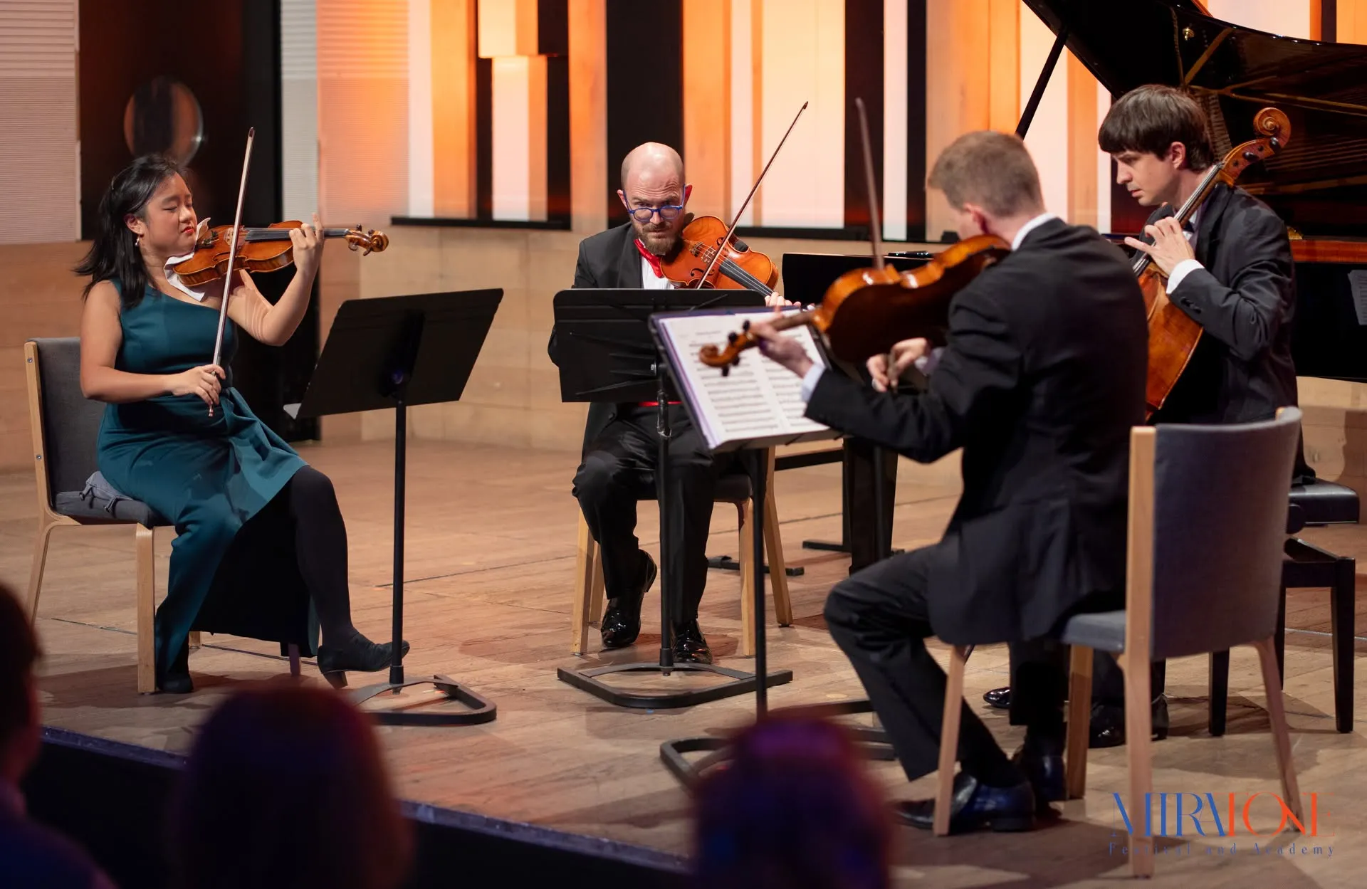 Four Classical Musicians Playing Their Instruments On Stage