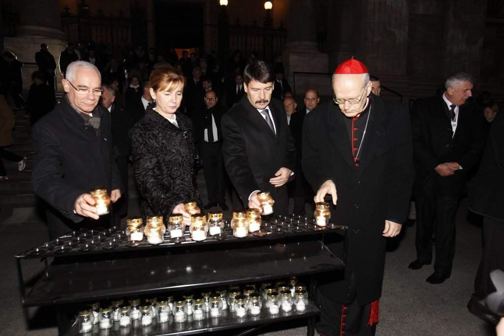 President János Áder and his wife lighting candles for the memory of the victims of the uprising