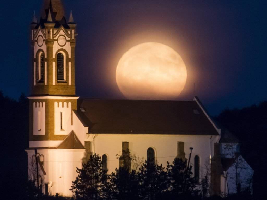 Sóshartyán, 14 novembre 2016. La superluna appare sopra la chiesa cattolica romana del Cuore di Gesù a Sóshartyán il 14 novembre 2016. Foto: Peter Komka / MTI