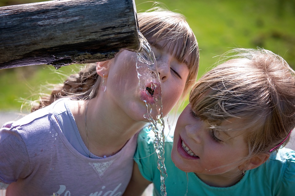Mädchen bewässern Hitzewellen-Außenpools