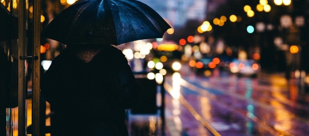 adult in the rain city dark
